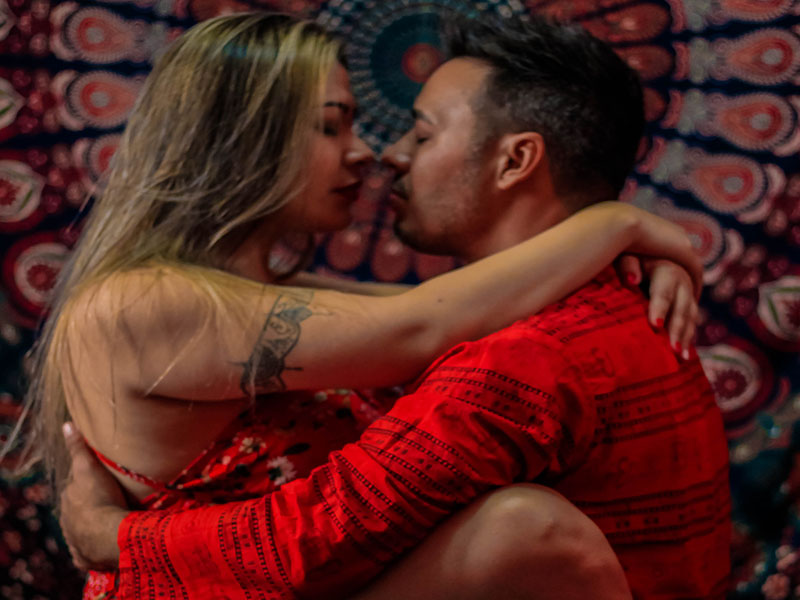 Casal abraçado em roupas vermelhas no curso de tantra para casais em Cuiabá